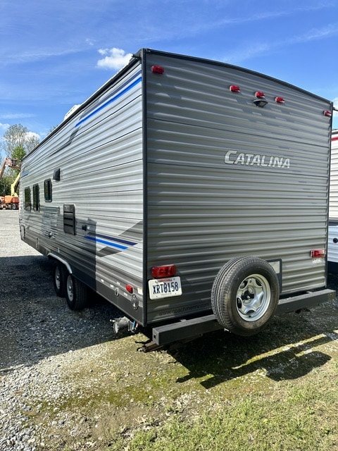 Gray Catalina travel trailer RV rental, with a rear spare tire and blue stripe detail.